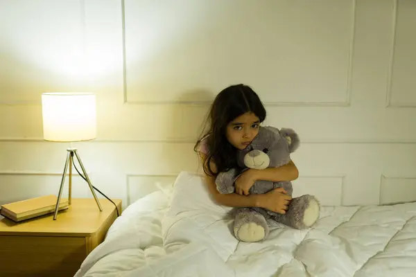 Spanisches Kleines Mädchen Umarmt Ihren Teddybär Der Nacht Fest Weichen lizenzfreie Stockbilder