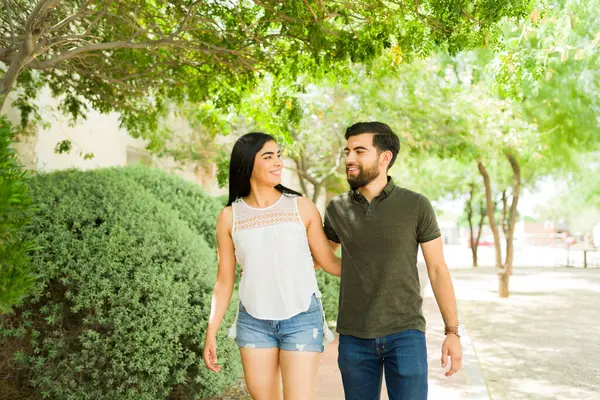 Junges Lateinisches Paar Lächelt Und Spaziert Zusammen Freien Und Genießt lizenzfreie Stockfotos