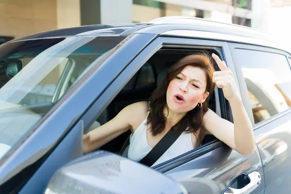 Upset Woman Expressing Annoyance While Driving Her Car Gesturing Frustration รูปภาพสต็อก
