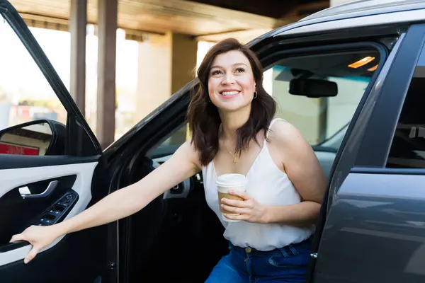 Smiling Woman Stepping Out Her Car Holding Coffee Cup Sunny รูปภาพสต็อกที่ปลอดค่าลิขสิทธิ์
