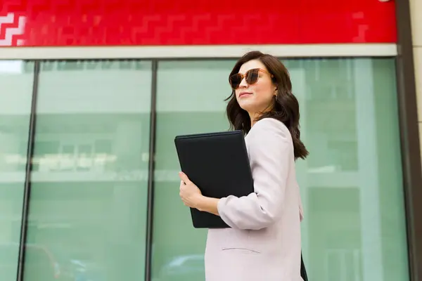 Confident Businesswoman Wearing Sunglasses Strolling Some Documents Hand City Environment ภาพถ่ายสต็อกที่ปลอดค่าลิขสิทธิ์
