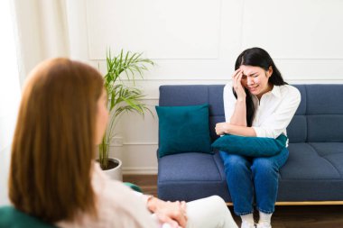 Distraught woman discusses her issues with a psychologist during a therapy session, emphasizing the importance of mental health support