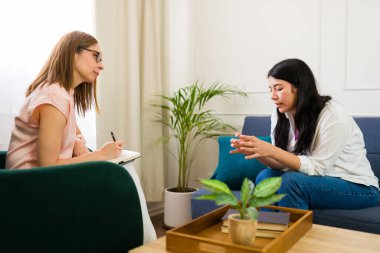 Compassionate female psychologist provides attentive support to a patient in a therapy session focused on mental health and emotional well-being