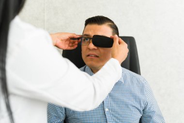 Ameliyattan sonra gözlerine bakması için göz bandı takan yetenekli bir göz doktoru.