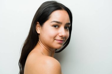 Stüdyoda güzel bir İspanyol kadının portresi, cildini cilt bakımı ve güzellik konseptinin bir parçası olarak gösteriyor.