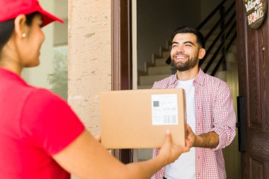 İspanyol genç bir adam, evine teslimat yapan bir kadın kuryeden bir paket alıyor.