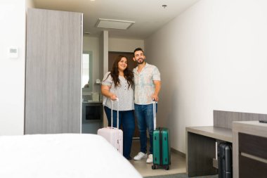 Kafkasyalı çift, bavullarıyla otel odalarına geliyor. Tatillerine başlamak için heyecanlılar.