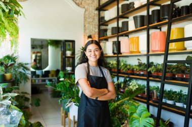 Kolları çapraz duran ve fabrika dükkanında gülümseyen mutlu genç İspanyol girişimci.