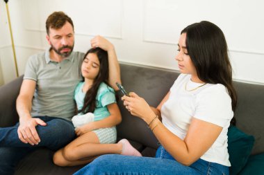 İspanyol anne evde hasta kızına hangi ilacı vereceğini kontrol etmek için tıbbi bir uygulama kullanıyor.