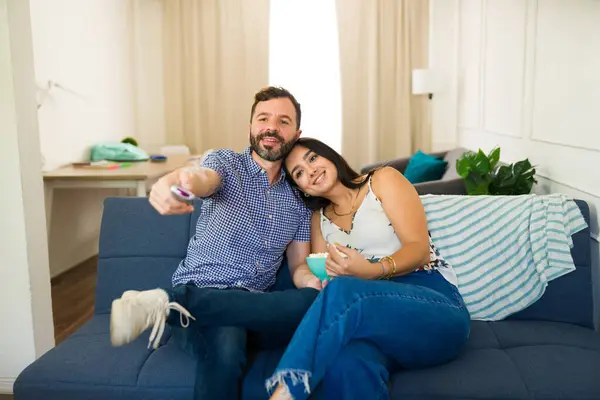 stock image Cute couple is spending quality time together, relaxing on their couch, enjoying a movie and eating popcorn