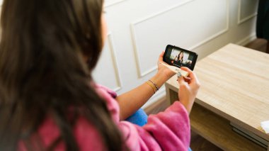 Hasta kadın bir termometreyle çevrimiçi tıbbi konsültasyon için doktorla görüntülü görüşme yapıyor.