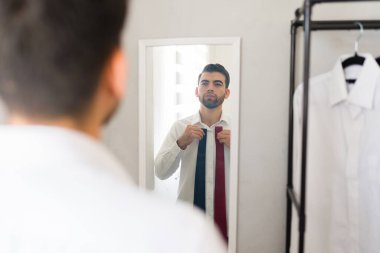 Latin işadamı sabah işe hazırlanırken iki farklı bağ arasında karar veriyor.