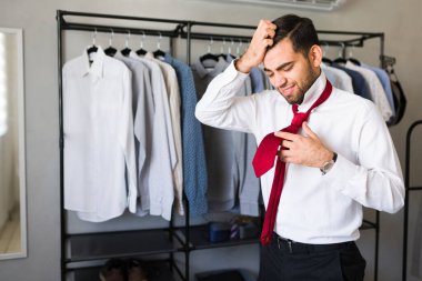 Latin adam işe gitmek için hazırlanırken ve kravatını bağlarken stresli bir sabah geçiriyor.