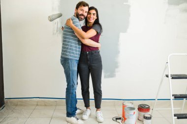 Yeni evlerini boyamaya ara veren bir çiftin boya malzemelerinin arasında rahatlama ve şefkat dolu bir anı.