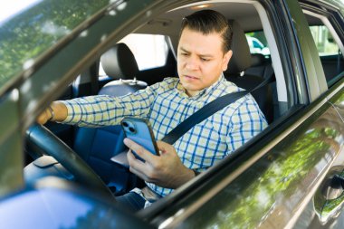 İspanyol işadamı arabasını sürerken cep telefonuna bakıyor, araba kazası riskiyle karşı karşıya.