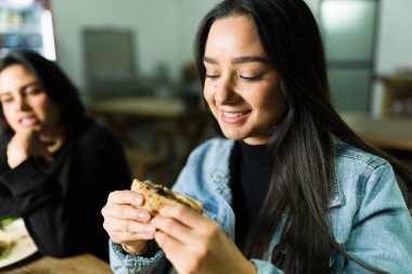 Memnun müşteri taco standında Quesadilla 'nın tadını çıkarıyor arkadaşlarıyla hakiki Meksika lezzetlerinin tadını çıkarıyor.