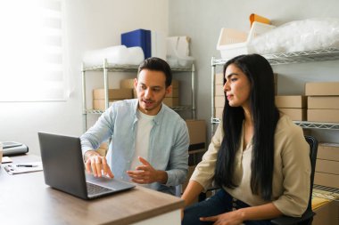 Latin girişimciler küçük işletme depolarında sıkı çalışır, dizüstü bilgisayarlarındaki online siparişleri yönetir, çevrimiçi mağazalarını büyütmeye ve müşterilere sorunsuz teslimat sağlamaya odaklanırlar.