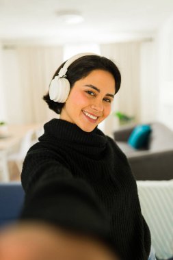 Kulaklık takan genç bir kadın video blogu kaydediyor ya da evden canlı yayın yapıyor.