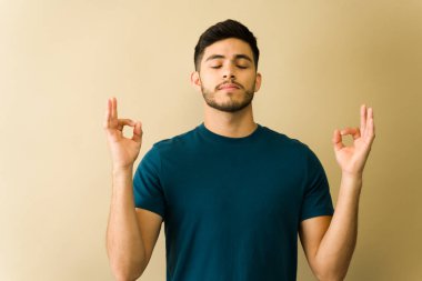 Rahatlamış genç adam yoga ve meditasyon yapıyor, konsantre oluyor ve nefes almaya odaklanıyor.