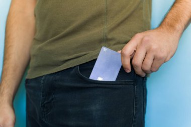 Temassız bir kredi kartını cebinden çıkaran bir adamın yakın plan fotoğrafı. Hızlı ve kolay bir ödeme için hazır.