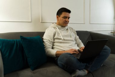 Uzaktan bilgisayarla çalışan serbest çalışan, oturma odasındaki ofisinin keyfini çıkaran biri.