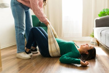 Ebe hamile kadınlar için rebozo masaj tekniği uyguluyor, sıcak bir oturma odasında ev ziyareti sırasında konfor ve destek sağlıyor.
