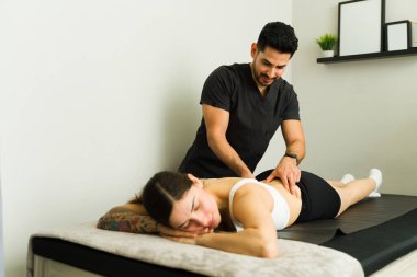 Latin fizyoterapist profesyonel tıbbi rehabilitasyon sırasında kadın hastaya terapi uyguluyor.