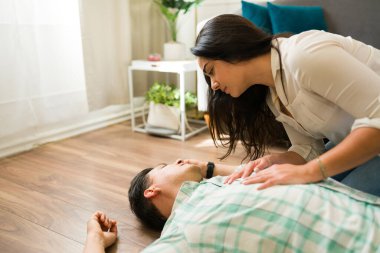 İspanyol kadın, sağlık sorunları yaşadıktan sonra evde yerde yatan baygın bir adama ilk yardım yapıyor.