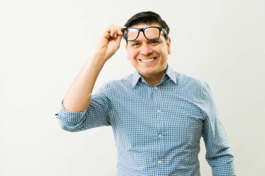 Kameraya gülümserken beyaz bir arka plana bakan neşeli, olgun bir adamın portresi.