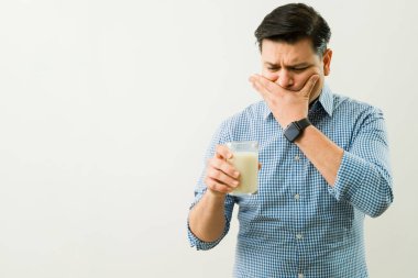 Süt içtikten sonra ağzını eliyle kapatan İspanyol adam laktoz intolerans belirtileri ve mide kramplarından muzdarip.