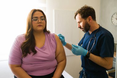 Bir hastanın koluna enjeksiyon yapılması, klinik bir ortamda gerekli tıbbi bakımı sağlamaktadır.