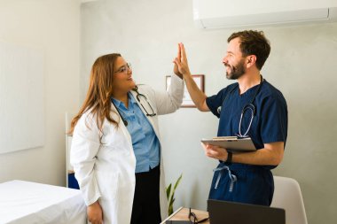 Çağdaş sağlık ortamında pozitif enerjili başarılı işbirliğini kutlayan, beşlik çakan tıp uzmanları