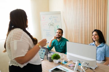 Modern bir ofiste iş birliği yapan iş adamları, üretken tartışmalar ve beyin fırtınası oturumları yapıyorlar.
