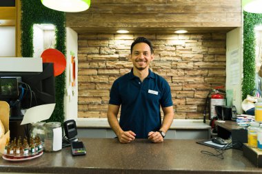 Kasanın arkasında durup bakkalda müşterileri bekleyen dost canlısı bir İspanyol işçinin portresi.