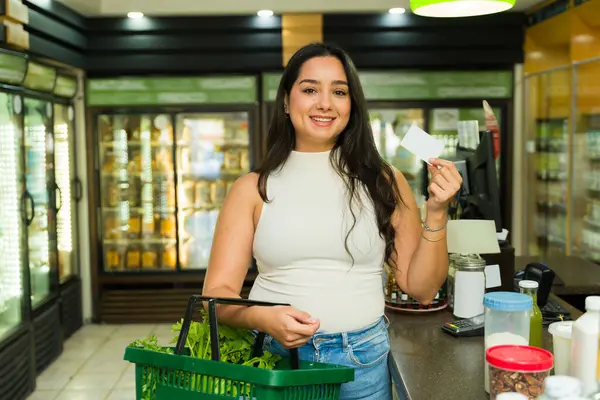 Neşeli Latin müşteriler, canlı bir süpermarkette alışveriş yaparken, sağlıklı yiyecek seçeneklerinin tadını çıkarıyorlar.