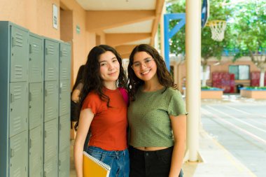 İki lise öğrencisi okul koridorunda birlikte vakit geçiriyorlar. Canlı ve dost canlısı bir eğitim ortamı sergiliyorlar.