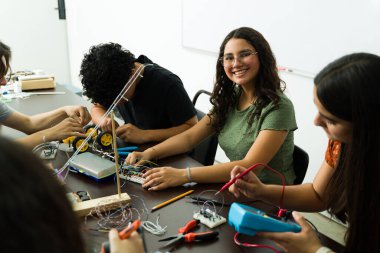 Latin Amerikalı öğrenciler, kendi lise elektronik laboratuvarlarında bir kök projesinde işbirliği yaparak, pratik öğrenme ve yenilikle ilgileniyorlar.