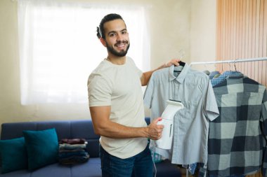 Evdeki gömlekleri portatif buharlı bir buharlı adam ev işlerini yönetiyor ve düzenli bir yaşam alanı sağlıyor.