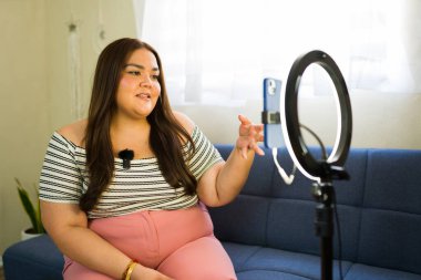 Latin içerik yaratıcısı akıllı telefon ve zil ışığıyla bir video bloğu kaydediyor, görüşleri paylaşıyor ve memleketten gelen takipçilerle bağlantı kuruyor