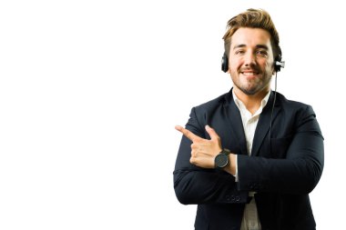 Dost canlısı, kulaklık takan ve çağrı merkezinde çalışırken parmağını yana doğru gösteren biri.