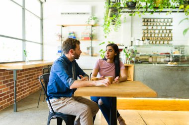 Sıcak bir atmosferle çevrili sıcak bir kafede kahvelerini yudumlarken genç İspanyol çift keyifli bir sohbetin tadını çıkarıyor.