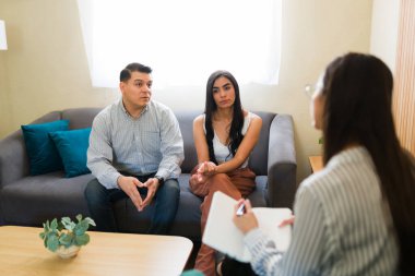 Çift terapisi sırasında psikologlardan profesyonel yardım alan Latin çift.