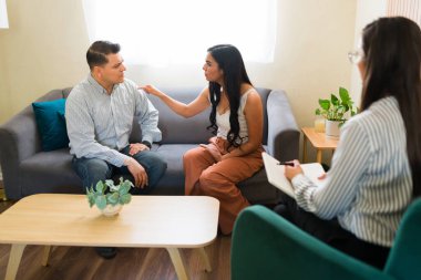 Profesyonel psikologların not aldığı çift terapisi sırasında Latin çift tartışıyor ve ilişki sorunları hakkında şikayet ediyor.