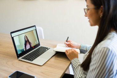 Bilgisayarda hastasıyla sanal terapi seansına katılıp uzaktan akıl sağlığı desteği sağlayan bir psikolog.