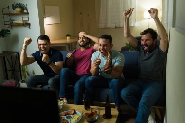 Bir grup İspanyol, televizyonda maç izlerken eğleniyor ve evde bira içip abur cubur yerken bir hedefi kutluyor.