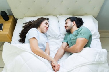 Genç aşıklar sabah yatakta uzanırken el ele tutuşur ve konuşurlar. Birlikte rahatlatıcı bir anın tadını çıkarırlar.