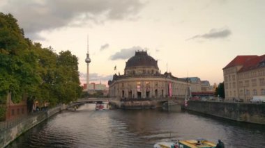 Berlin, Almanya, 1 Ekim 2022: Berlin 'de gün batımında Spree Nehri üzerinde hareket eden bir turist gemisinin manzarası