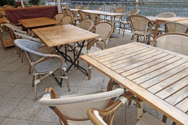 Boş kafe terası. Nehrin kıyısında boş masa ve sandalyeler