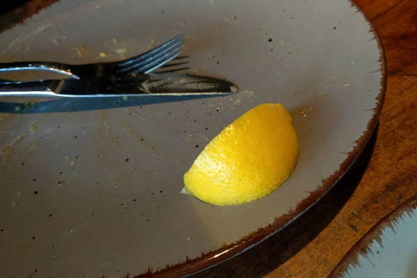 吃完饭后放在脏盘子上的一片黄色柠檬 — 图库照片