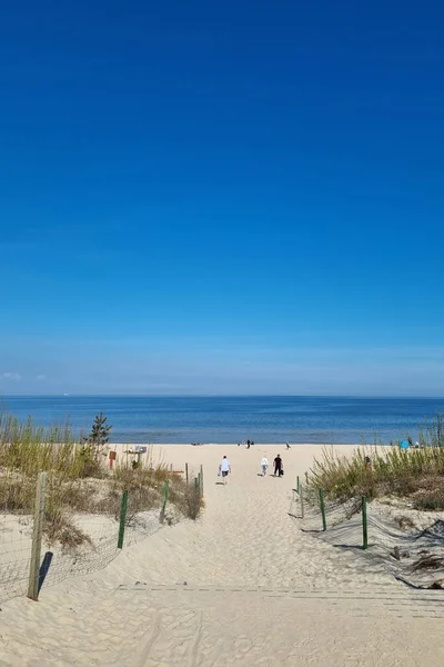 往大海或大海的砂质出口的景观 海滩上的度假者 阳光灿烂温暖的一天 在海上休息 — 图库照片